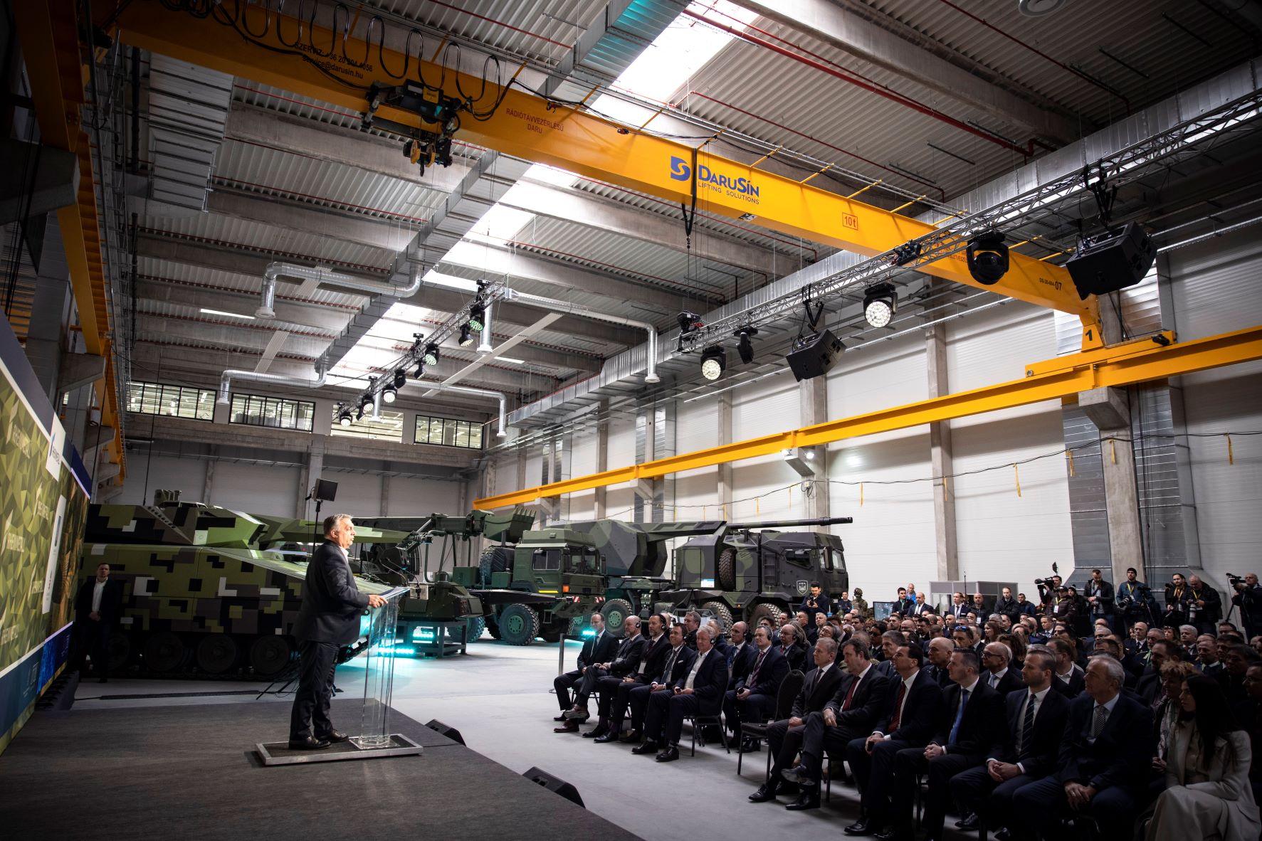 Orbán Viktor, miniszterelnök a zalaegerszegi Lynx üzem átadóján, a háttérben egy Lynx harcjármű, egy Rheinmetall műszaki jármű, illetve egy Rheinmetall 10 kerék meghajtásos 155mm-es önjáró löveg;